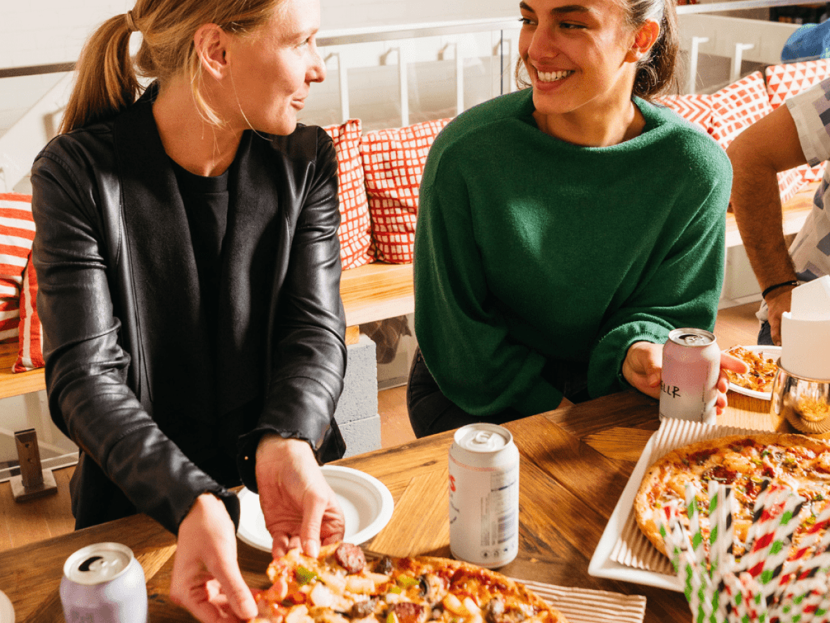 a person sitting at a table eating pizza
