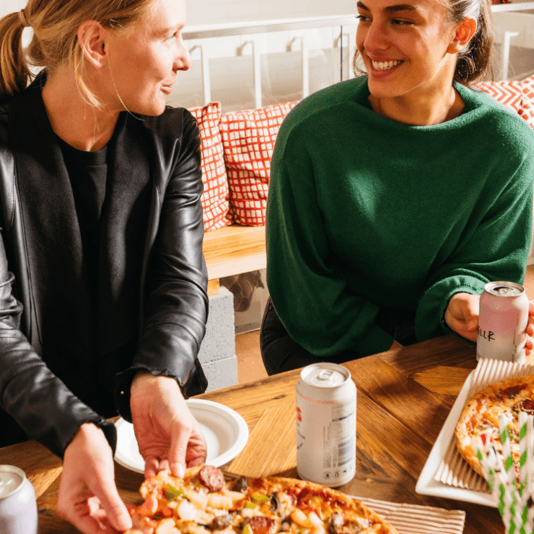 a person sitting at a table eating pizza