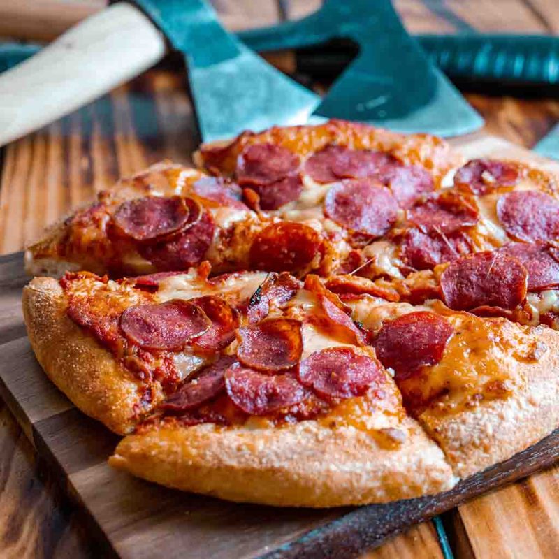 a slice of pizza sitting on top of a wooden cutting board