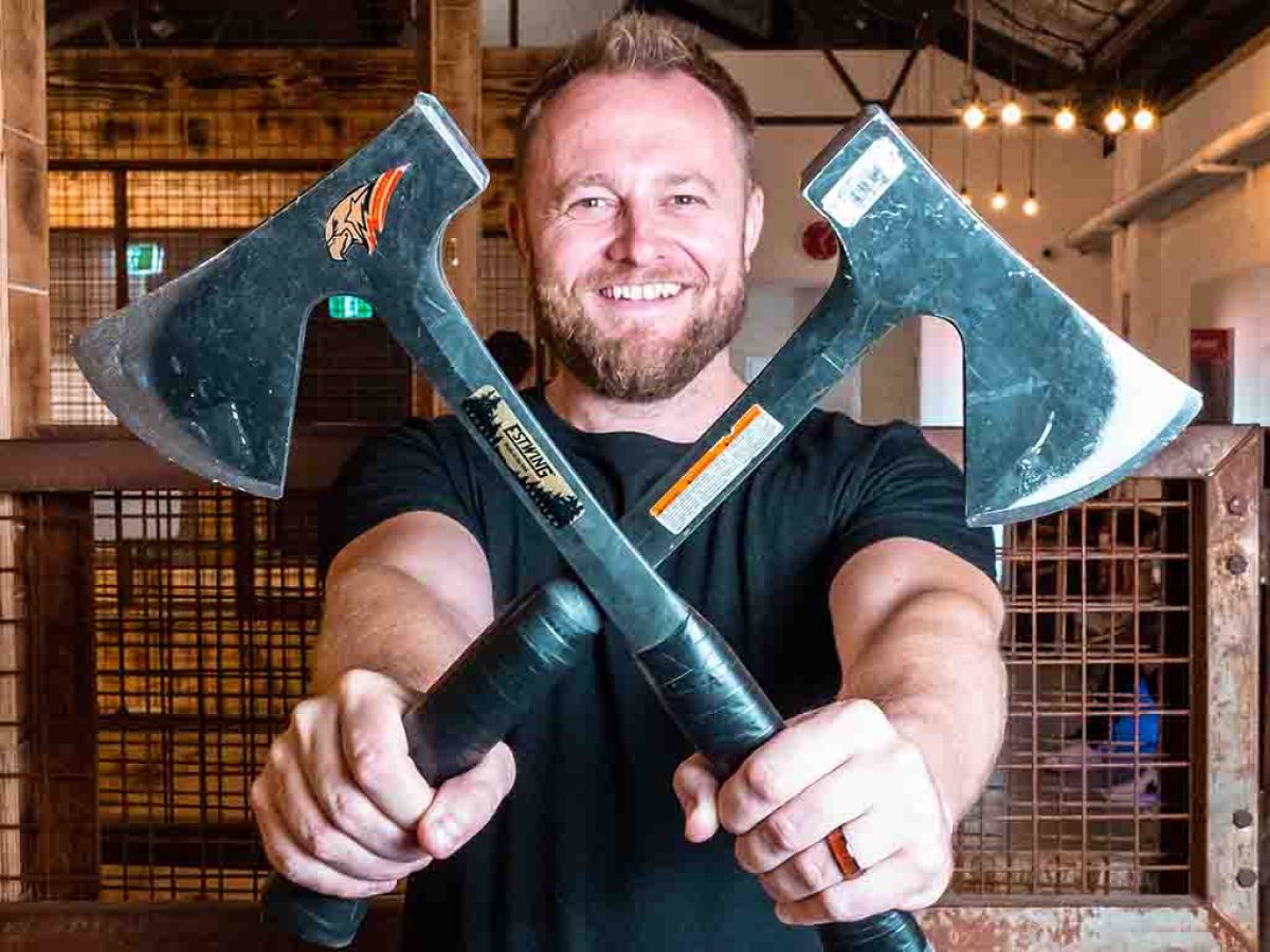 guy holding up two axes crossed at the middle blades pointing out