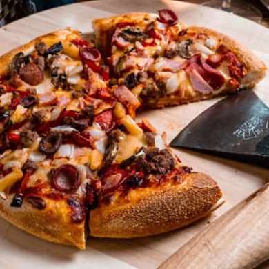 a slice of pizza sitting on top of a wooden cutting board