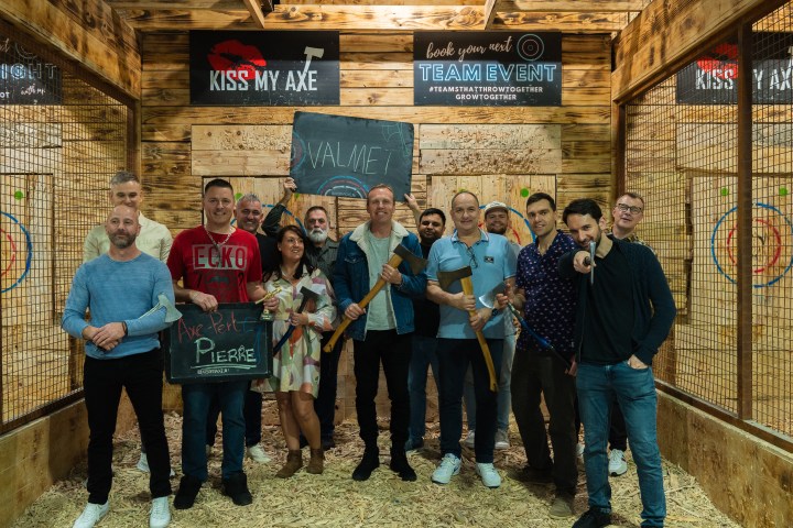 Group smiling during team event axe throwing