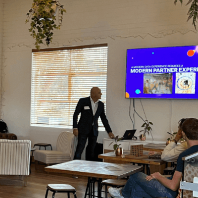 People in a modern meeting room listening to a presentation on a screen.