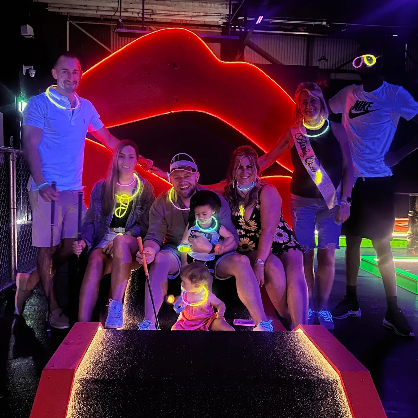 Birthday group plays glow in the dark mini golf