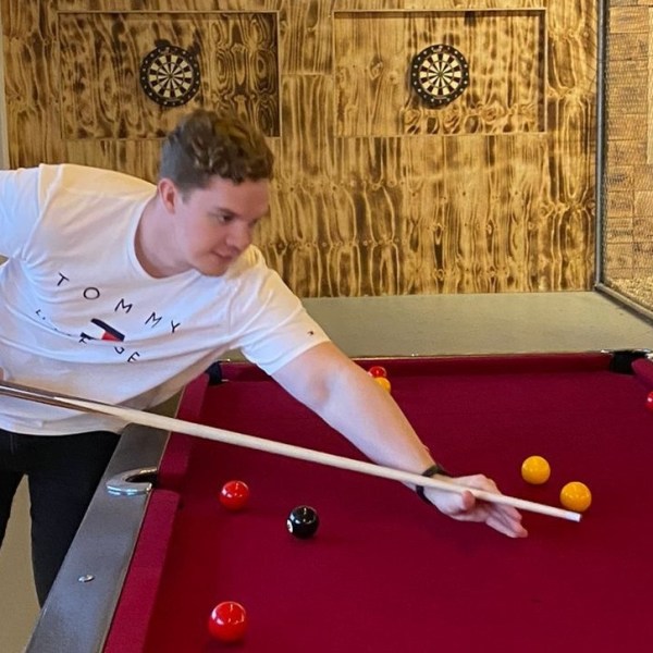 guy aiming to put a ball in a pocket of a pool table