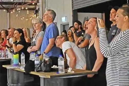 a group of people standing around a table