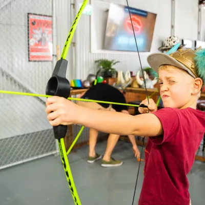 kid holding up an archery bow and arrow