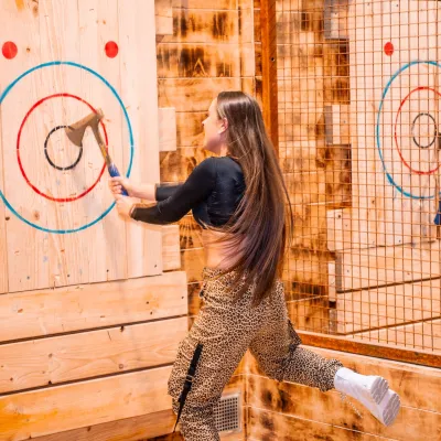 girl retrieving her axe from the center of the target
