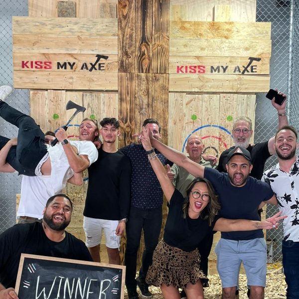 Group of people celebrating at an axe-throwing venue.