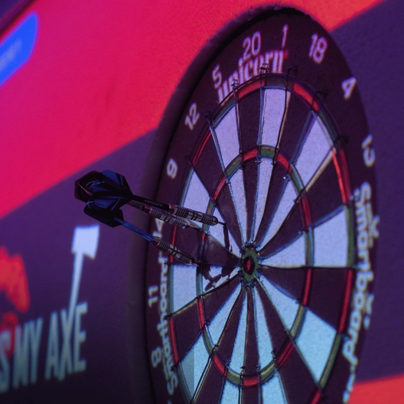 Dartboard with three darts on a projected game screen.