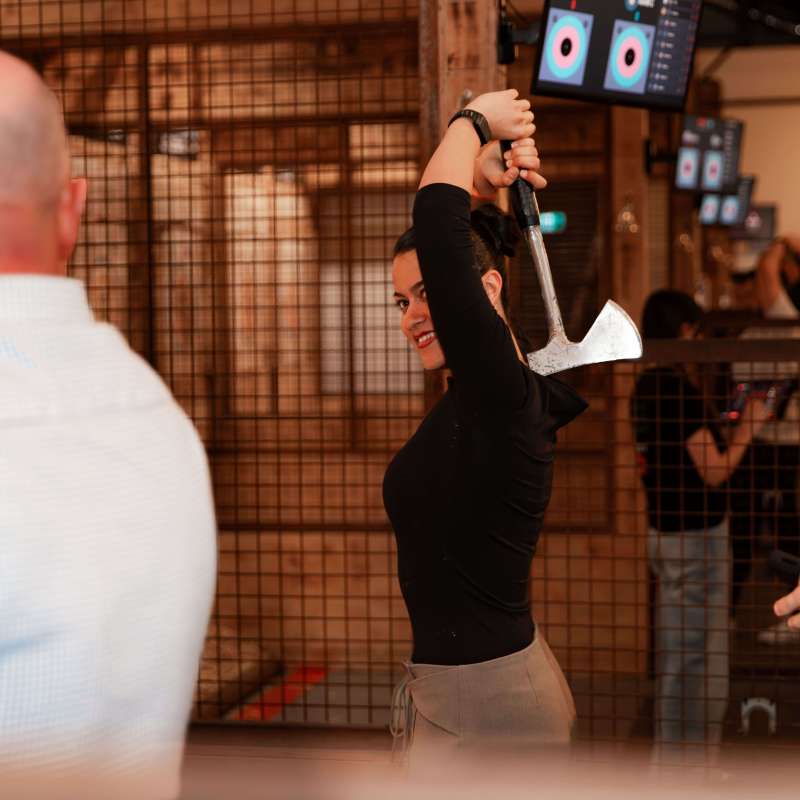 Person prepares to throw an axe at an indoor range.