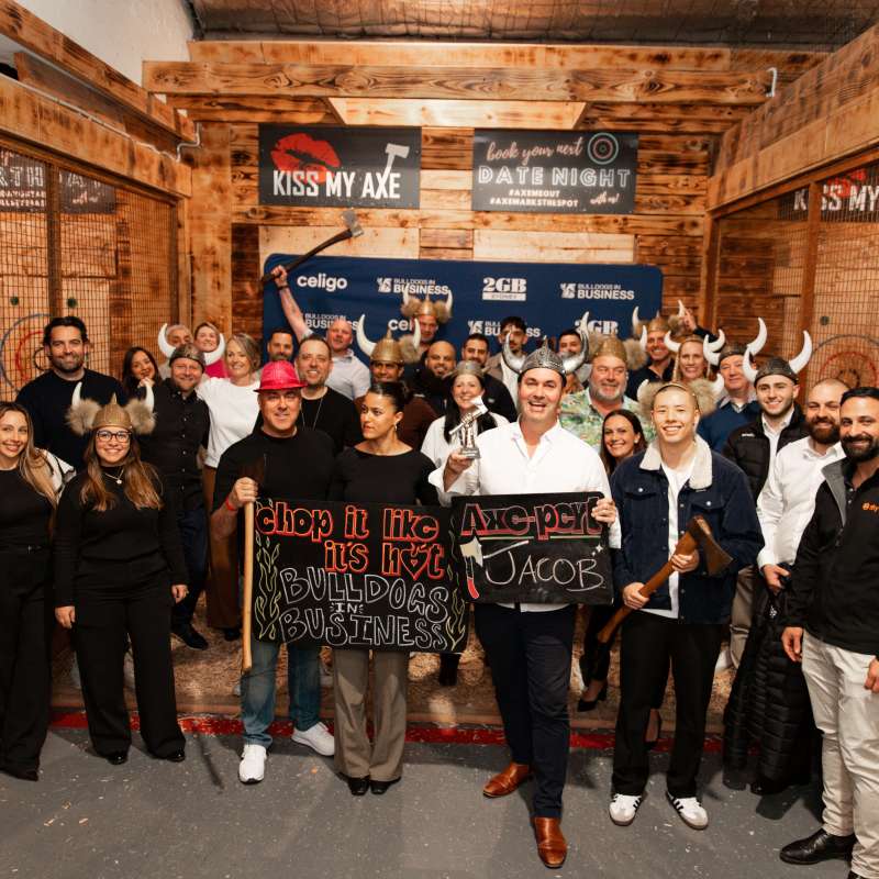 Group of people posing at an indoor axe-throwing venue.