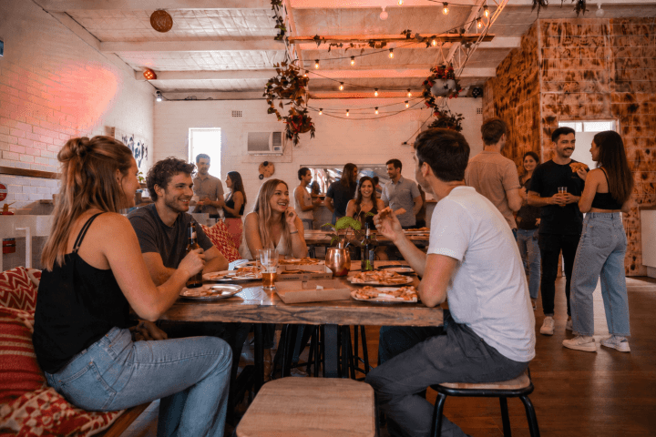 People socializing at a cozy indoor gathering with string lights.