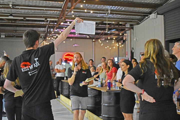 Person with microphone leading an auction in a lively indoor venue.